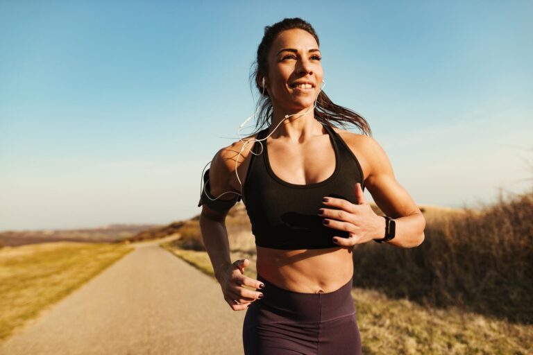 instructor-fitness-sonriente-corriendo-mientras-hace-ejercicio-naturaleza-copiar-espacio_637285-5142